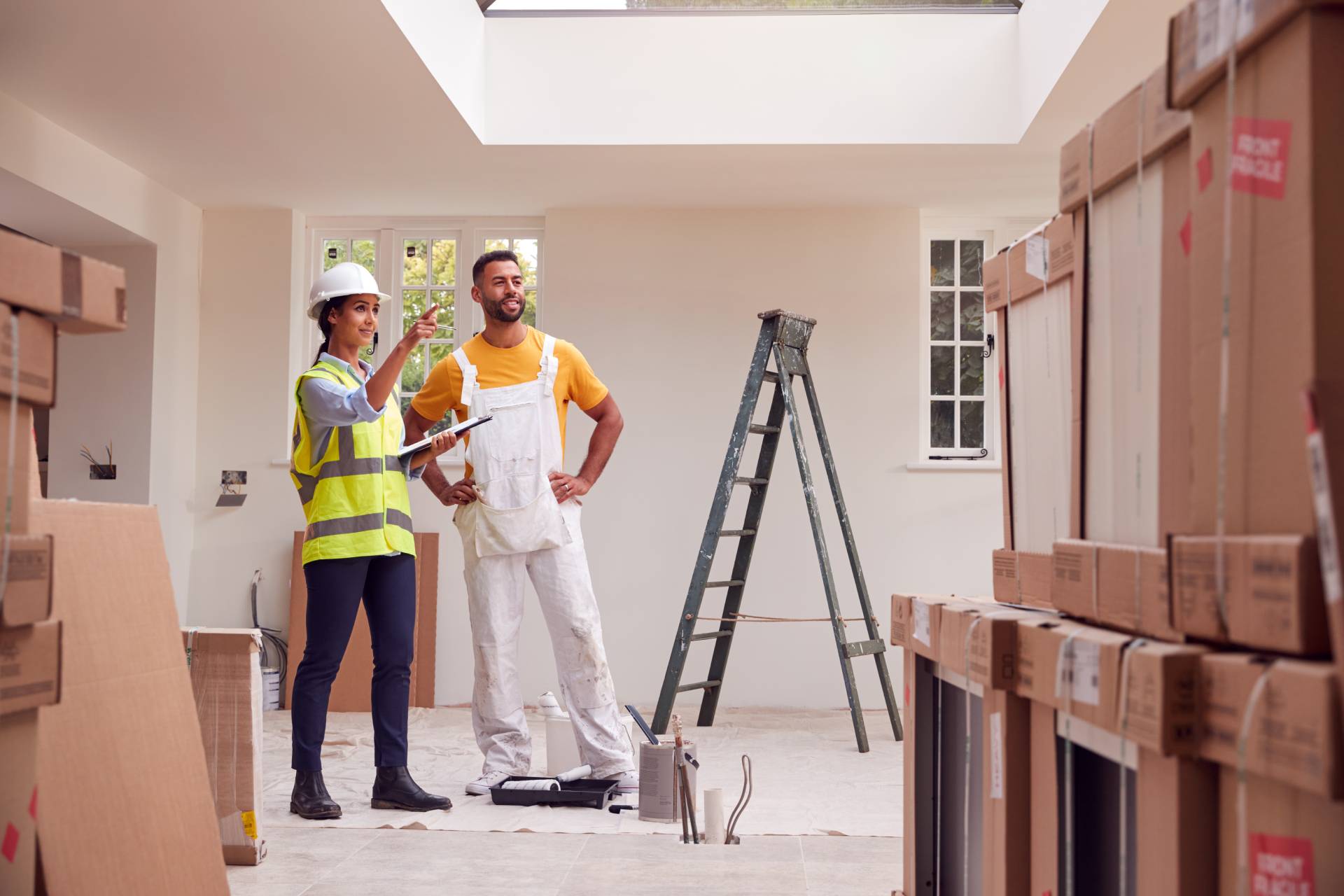 Construction workers discussing plans inside a room being renovated