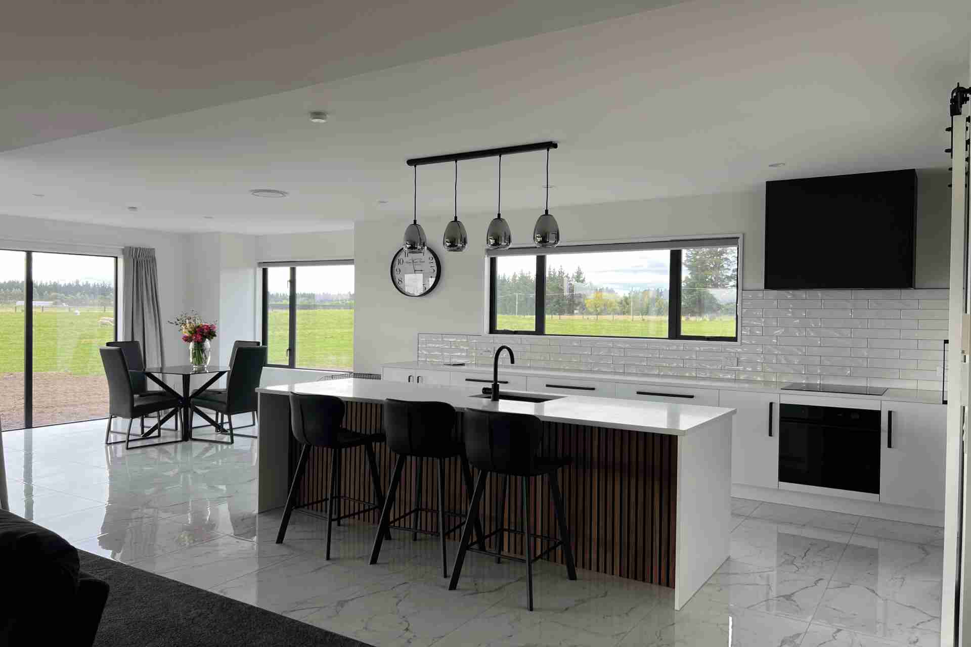 minimalist kitchen with island seating and wall clock