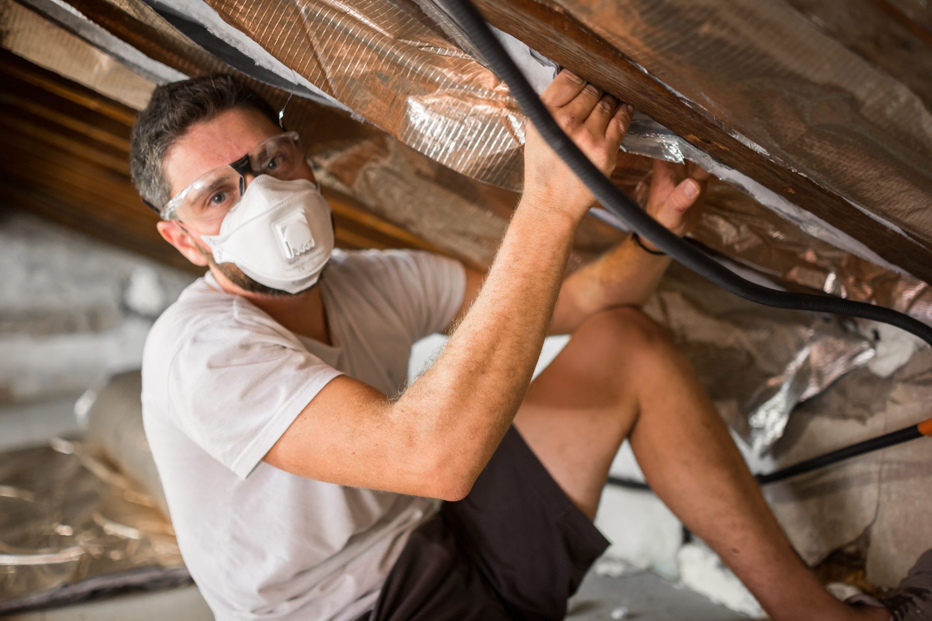 A man fixing insulation of roof