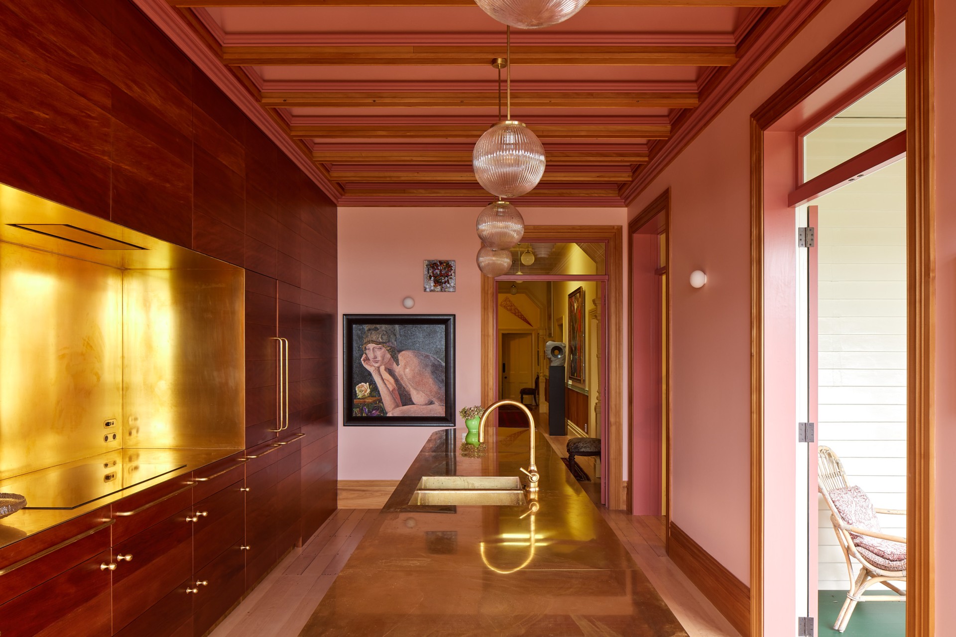 Pink kitchen with gold island counter.