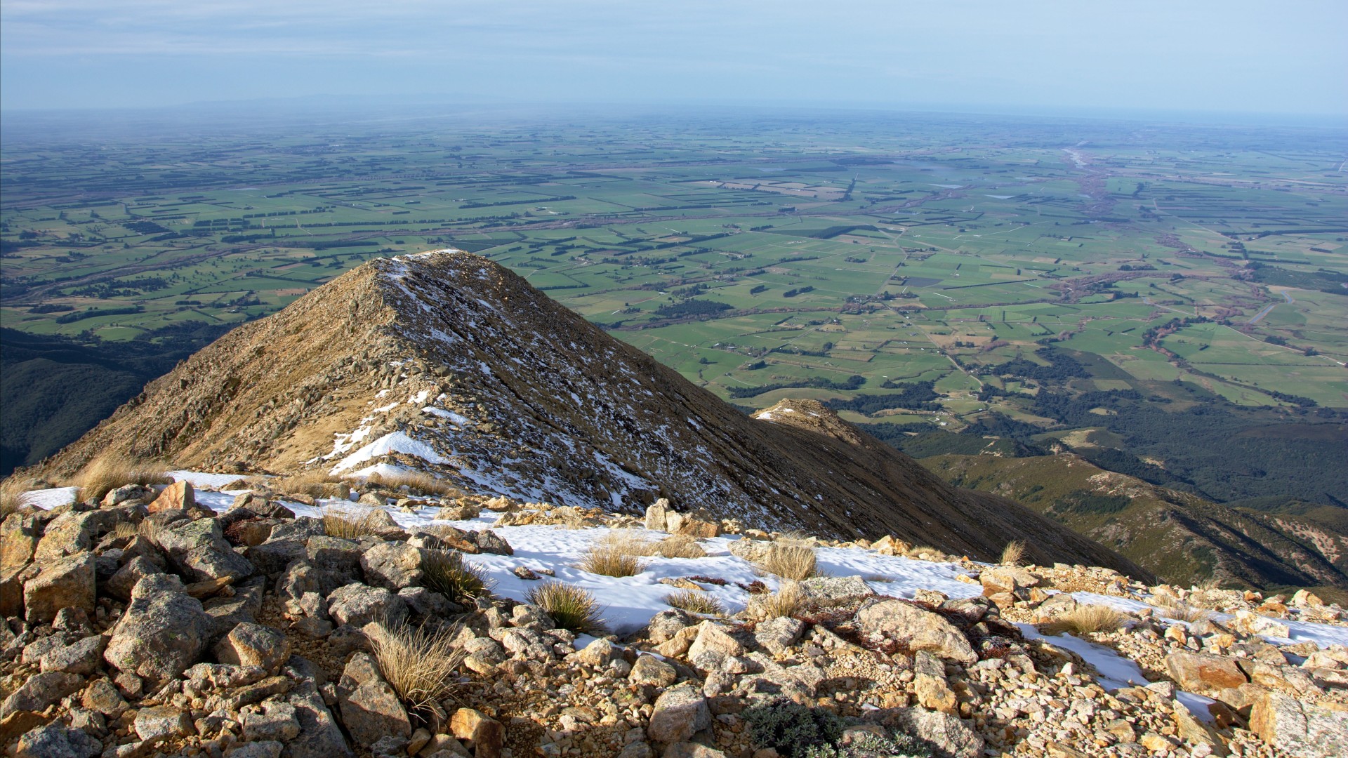 Snow-dusted mountain ridge overlooking Canterbury farmland