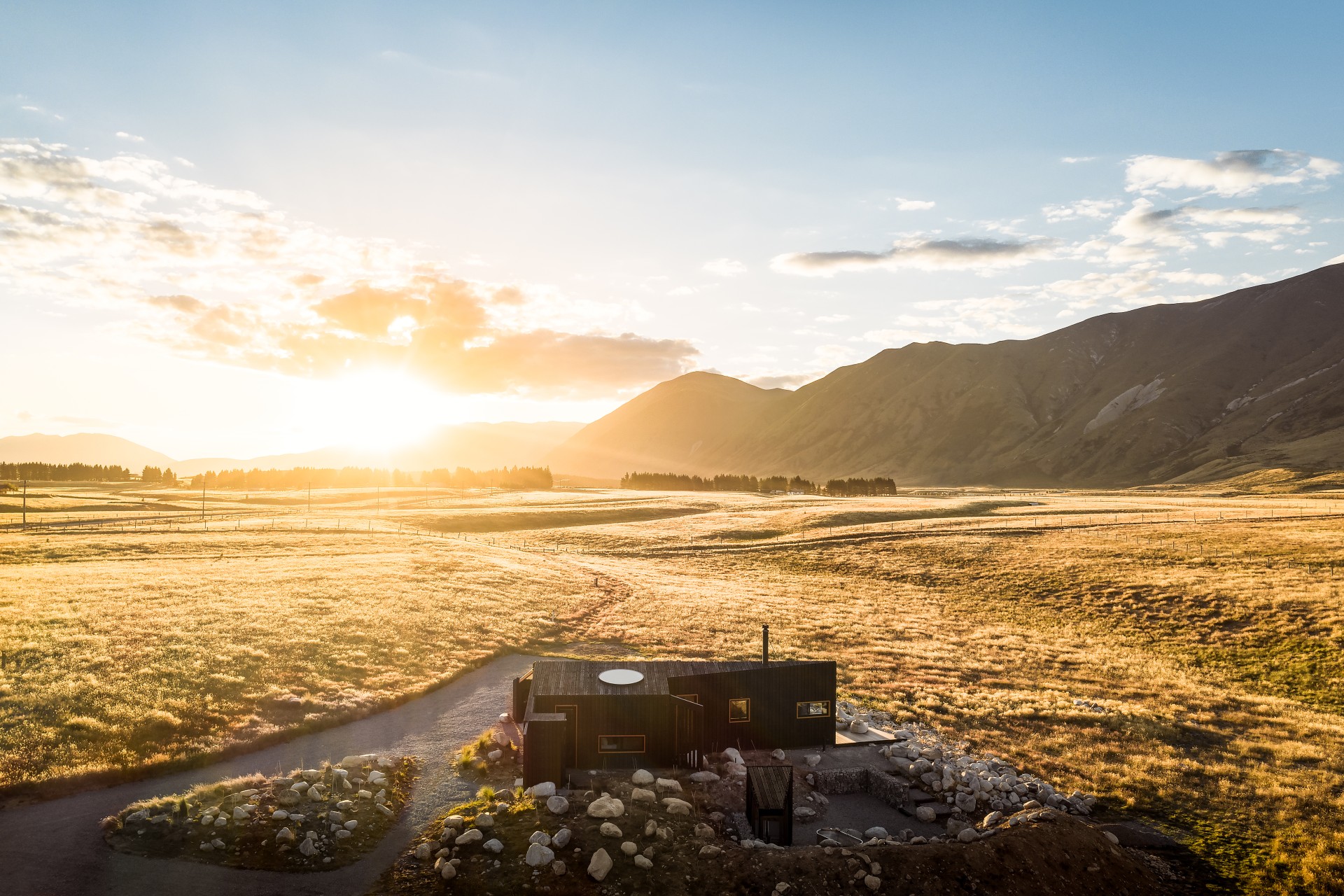 Modern home overlooking a rural New Zealand landscape at sunrise