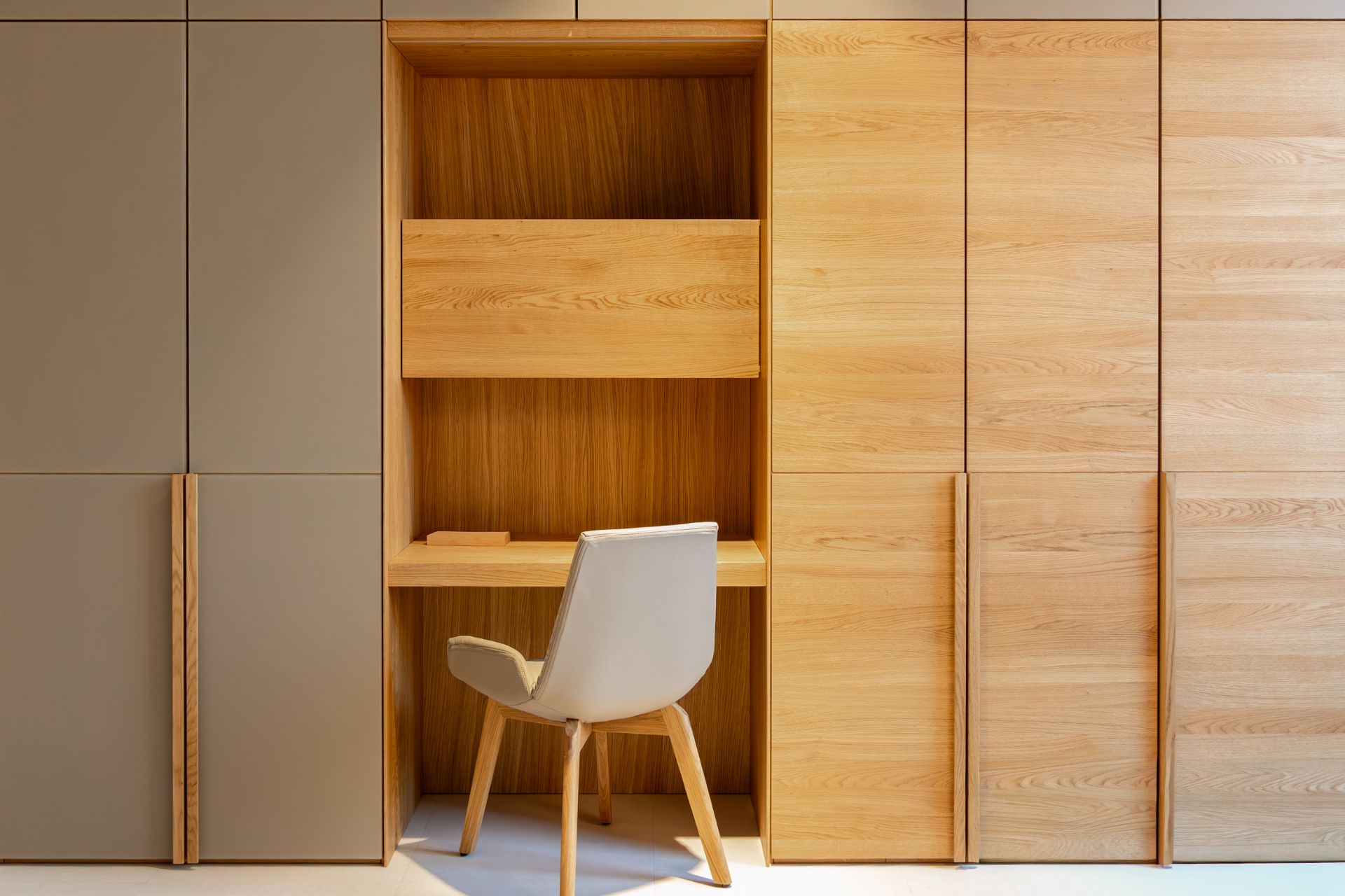 Built-in study nook with storage cupboards and a chair