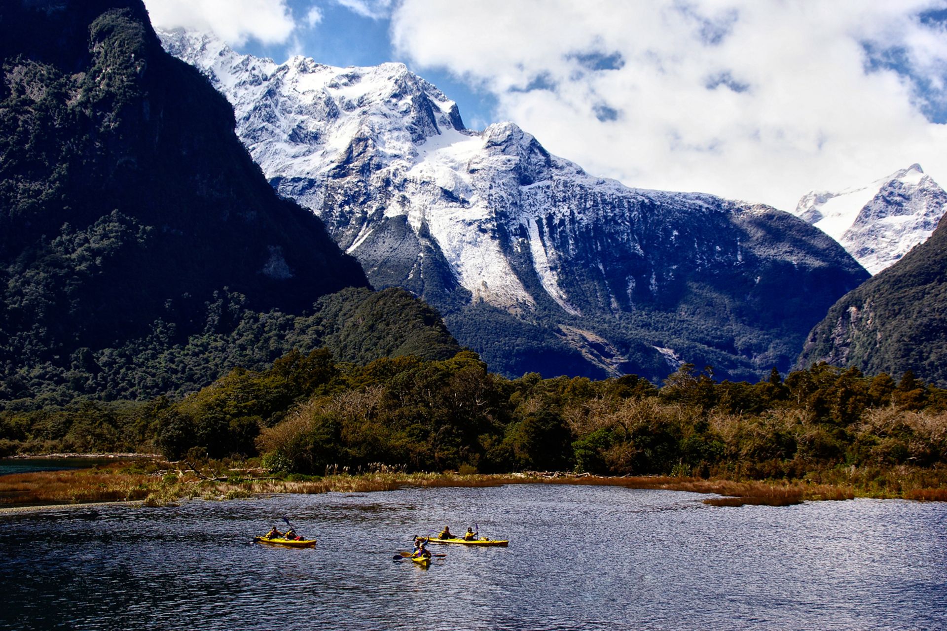 Scenic view of Milford Sound surrounded by dramatic mountains in New Zealand.