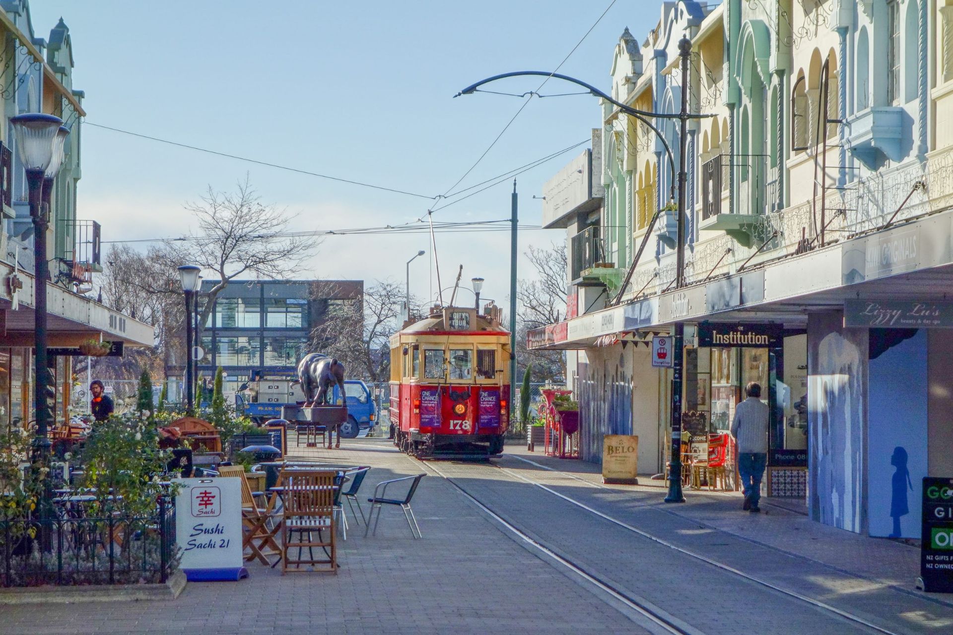 Christchurch street lined with colourful historic buildings, outdoor cafés and a heritage tram running along the central city tram tracks.