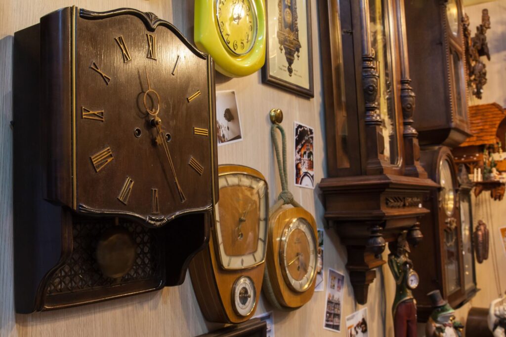 Collection of vintage and decorative clocks displayed on a wall.